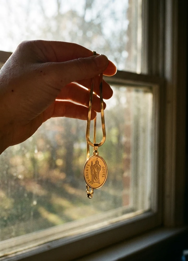 Holding the gold St. Jude™ Hope Pendant